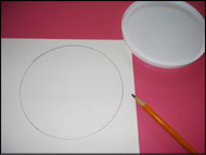 Tracez le couvercle en plastique rond sur le carton blanc et découpez le cercle.